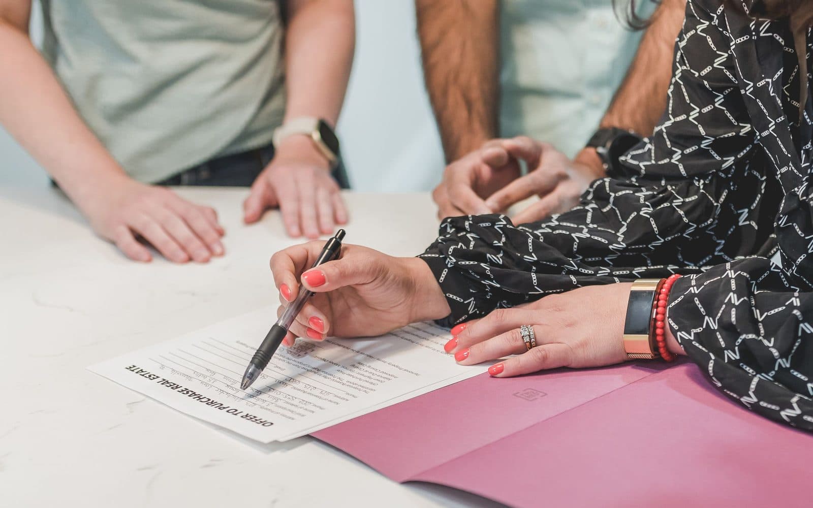 Un primer plano de un contrato de bienes raíces siendo firmado con una pluma