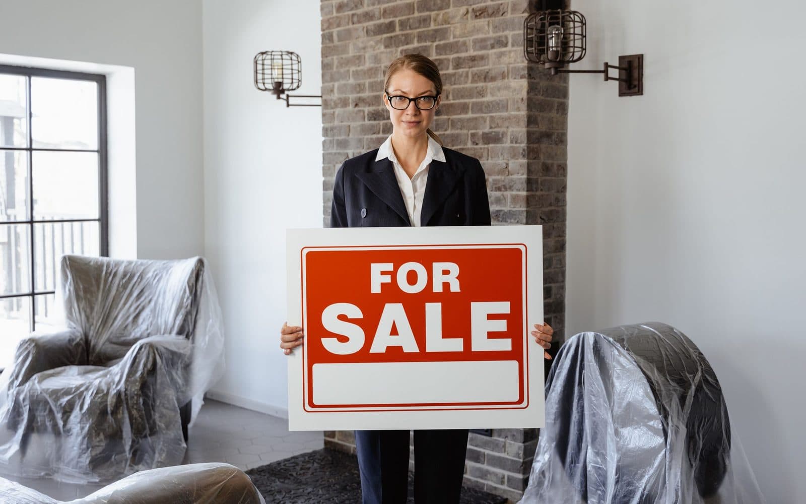 Un letrero de venta frente a una casa representando una decisión de venta